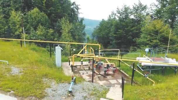 Uitzicht vanuit de lucht klein benzinestation gelegen op de top van de berg. Gasdistributiecomplex in de bergen midden in het bos. — Stockvideo