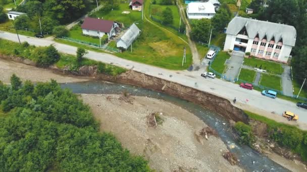 Vista aerea strada nel villaggio che è stato distrutto da un'alluvione sul fiume. La strada asfaltata che è stata tolta lavando dal fiume di montagna è distrutta. — Video Stock