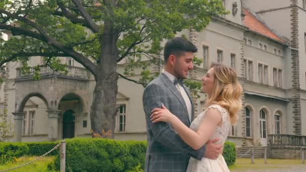 Couple de jeunes mariés marchant dans le parc. Deux jeunes amoureux se rencontrent les yeux — Video