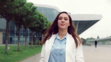 Güzel beyaz bir kadının portresi gülümseyen ve kameraya bakan. Sokaktaki kız kameraya gülümseyen modern iç mekanların arka planında..