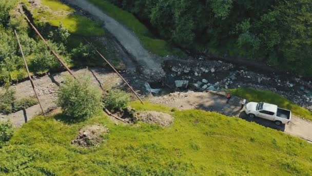 Гірська річка, яка знищила дорогу. Машина, яка не може пройти по дорозі, зруйнованій гірською річкою . — стокове відео