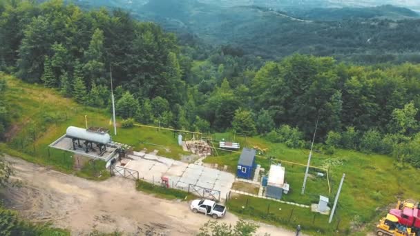 Uitzicht vanuit de lucht klein benzinestation gelegen op de top van de berg. Gasdistributiecomplex in de bergen midden in het bos. — Stockvideo