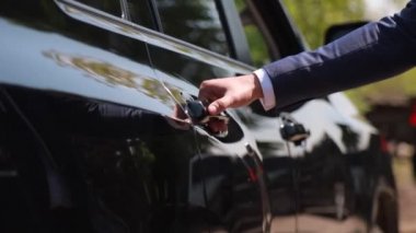 Erkek eli siyah birinci sınıf bir arabanın kapısını açar..