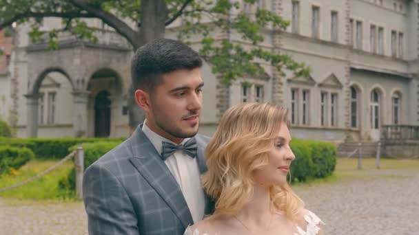 Frisch vermähltes Hochzeitspaar beim Spaziergang im Park. Zwei verliebte junge Menschen begegnen einander in den Augen — Stockvideo