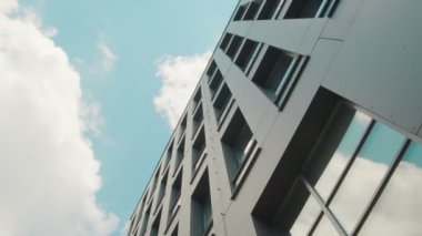 Modern bir iş merkezi binasının ön cephesinin bir parçası da aşağıdan yukarıya bakmaktır. Gökyüzü binanın pencerelerine yansıdı..