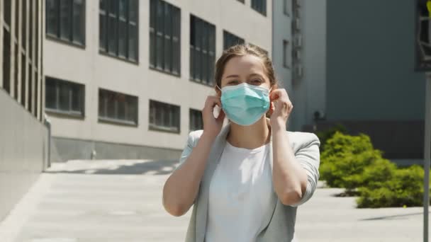 女人摘下她的防护面具，享受大都市街道上的新鲜空气。完成Covid检疫. — 图库视频影像