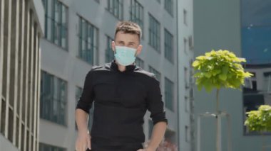 Bir cholovik yaky znimak portresi bir tıbbi maske çizecek ve kameraya hayret edecek.