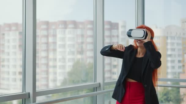 VR gözlük takan güzel, kızıl saçlı bir kadın. Kadın sanal gerçeklikte. VR gözlükleri sayesinde.. — Stok video