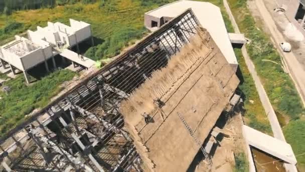 Uitzicht vanuit de lucht op het dak van een groot huis met droog stro en hooi. Werknemers die het dak installeren. — Stockvideo