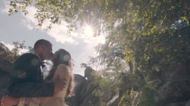 Parkta sokakta birbirini seven iki gencin gerçek bir öpücüğü. Güneşli bir günde genç insanların samimi öpücüğü.