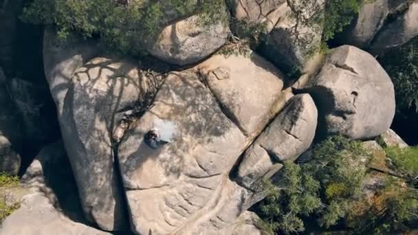 Couple de mariage en pierre de montagne de drone. Vue Aérienne Heureux jeunes mariés amoureux étreignant debout sur le sommet de la montagne. — Video