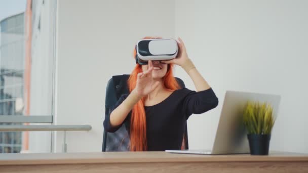 Junge hübsche rothaarige Frau mit VR-Brille. Die Frau ist dank VR-Brille in virtueller Realität. — Stockvideo