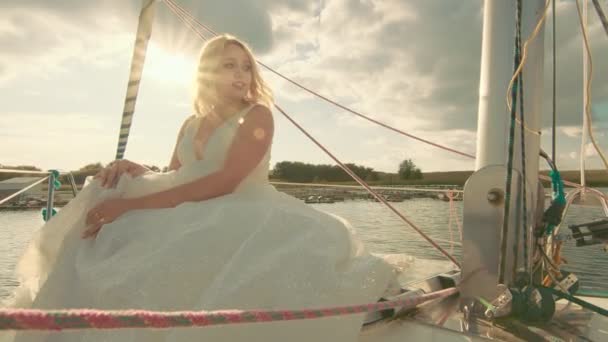 日落时,新娘坐在游艇上.新娘凝视着远方的阳光 — 图库视频影像
