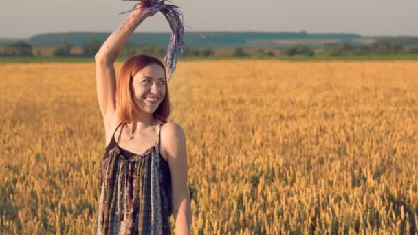 Portret van een vrouwelijke kunstenaar die emoties en glimlachen toont. Vrouw houdt in haar handen oren van tarwe ingesmeerd met verf. — Stockvideo