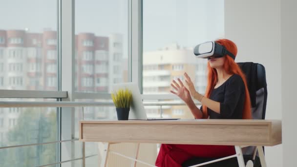 Ung, rødhåret kvinne med VR-briller. Kvinnen er i en virtuell virkelighet takket være VR-briller. – stockvideo