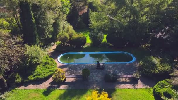 Vieille piscine abandonnée avec de l'eau verte sale. Vol au-dessus d'un bel espace vert avec une piscine abandonnée. — Video
