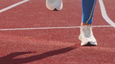 Koşu bandında zıplamaya başlamadan önce ısınan bir sporcunun bacakları.