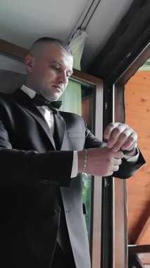 Damat saate bakıyor. Düğün sabahında damatlar. Saatli bir el..