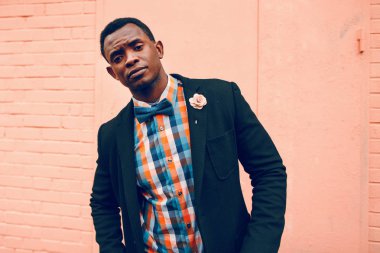 Pembe arka planda siyah adam