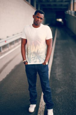 Koyu renkli bir tünelde beyaz tişörtlü siyah adam