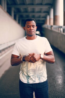 Koyu renkli bir tünelde beyaz tişörtlü siyah adam