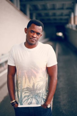 Koyu renkli bir tünelde beyaz tişörtlü siyah adam