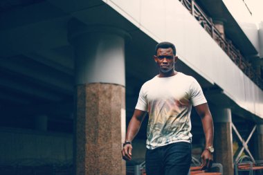 Koyu renkli bir tünelde beyaz tişörtlü siyah adam