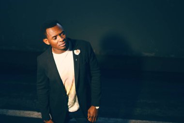 Koyu renk bir odada koyu renk takım elbiseli siyah adam