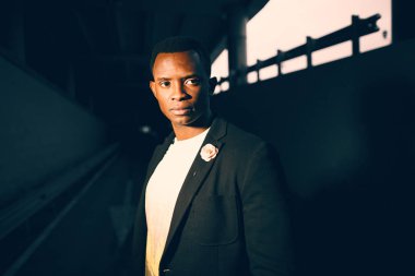 Koyu renk bir odada koyu renk takım elbiseli siyah adam