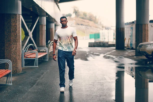 Koyu renkli bir tünelde beyaz tişörtlü siyah adam