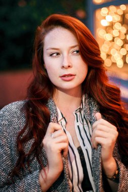 Sokaktaki çelenklerin arka planında manken pozu