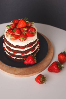 Koyu arka plan üzerinde kabuk ile Çilekli kek