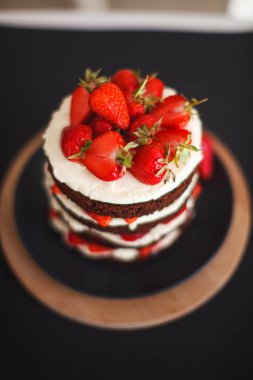 Koyu arka plan üzerinde kabuk ile Çilekli kek