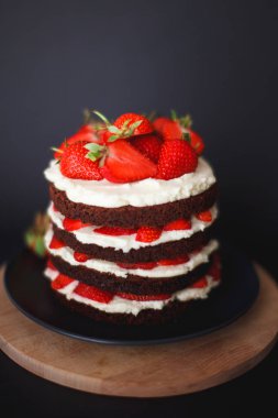 Koyu arka plan üzerinde kabuk ile Çilekli kek