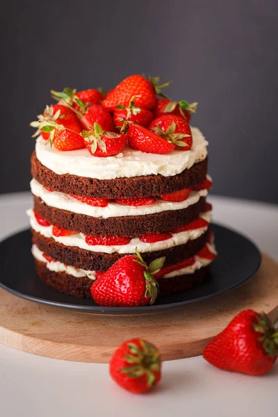 Koyu arka plan üzerinde kabuk ile Çilekli kek