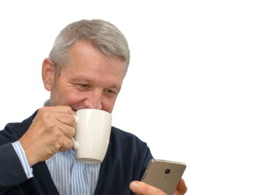 Kahve içme ve smartphone kullanarak olgun iş adamı