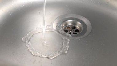 Mutfak lavaboda bir musluktan akan su akışı. Ağır çekim