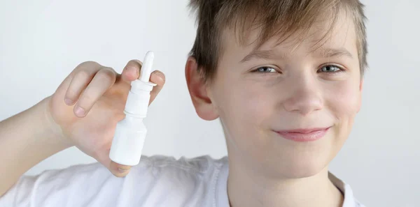 Chłopiec trzyma aerozol do nosa i uśmiechając się — Zdjęcie stockowe