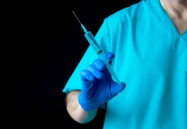 Doktor tıbbi enjeksiyon şırınga tutarak siyah