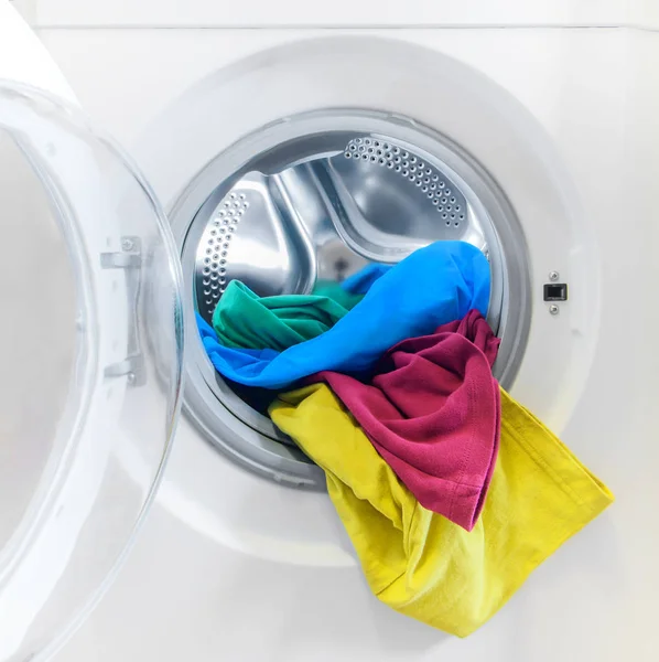 Tvättmaskin laddad med färgglada kläder — Stockfoto