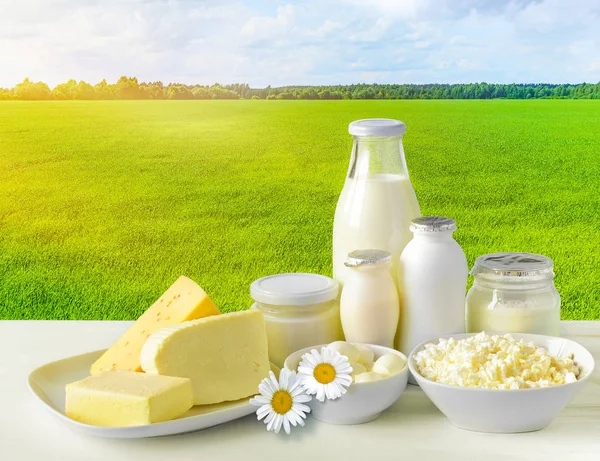 Dairy products on the green field and sky background.