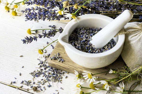 Beyaz ahşap arka plan üzerinde beyaz harç kuru lavanta çiçekleri. Bitkisel ilaç arka plan