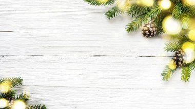 Beyaz ahşap arka plan üzerinde Noel ağacı dalları ve çam kozalaları.