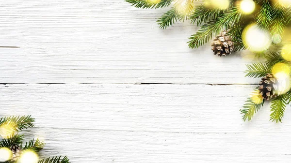 Christmas tree branches and pine cones on white wooden background. — Stock Photo, Image