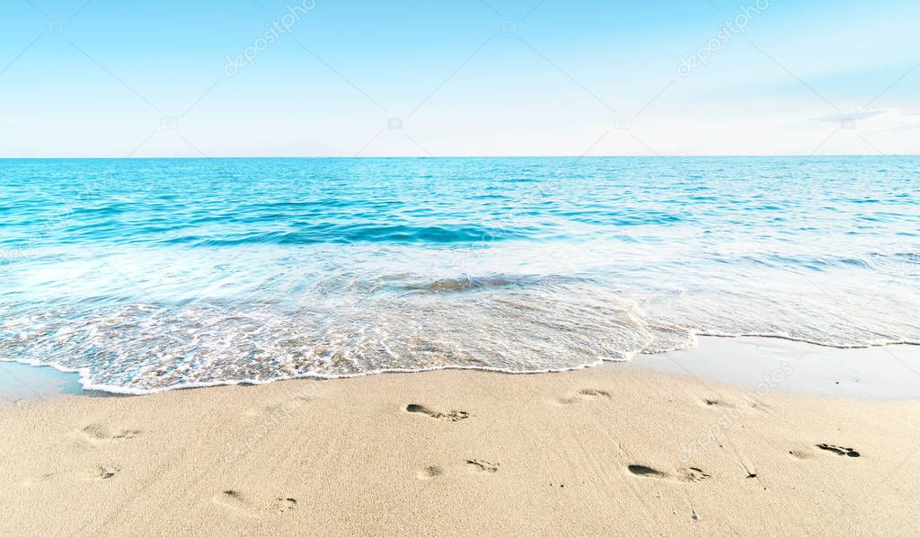 Landscape of sea sky and sand beach with footprints