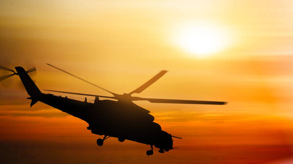 Силуэт вертолета, летящий в небе на закате
