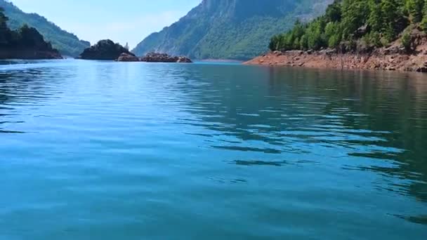 Seguimiento de disparo desde una popa barco flotando en un hermoso lago en las montañas . — Vídeo de stock