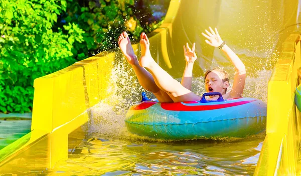 Хлопчик розважається на жовтому водяному гірці в аквапарку — стокове фото
