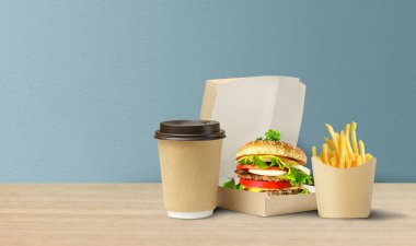 Lezzetli Hamburger, patates kızartması ve karton pakette kahve..