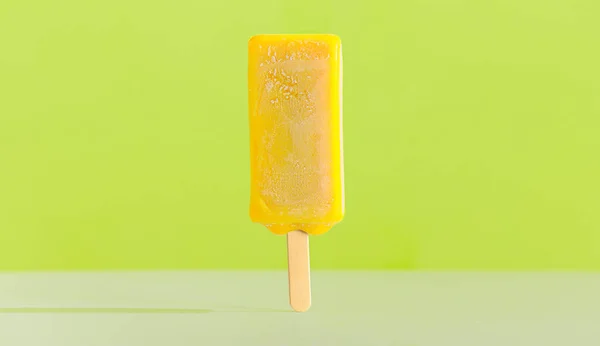 Gelado amarelo brilhante em um pau. Sabor de limão — Fotografia de Stock